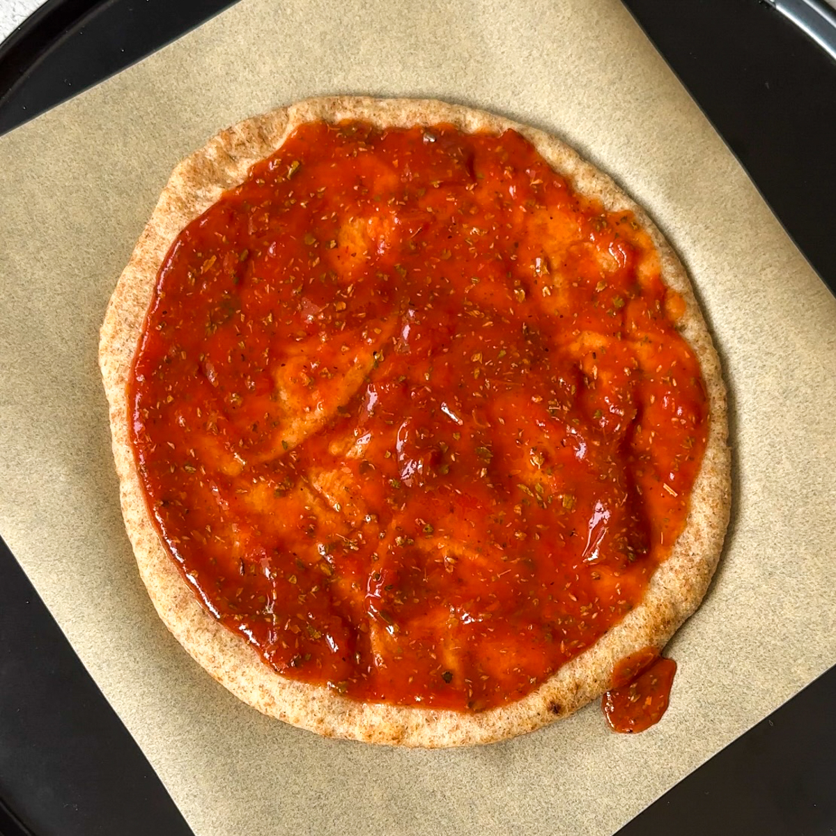 Add tomato sauce mixture to naan bread.