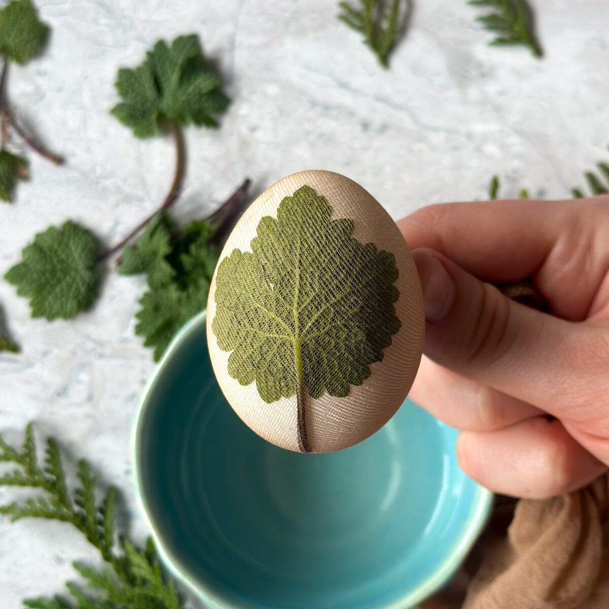 Than Place the egg into a piece of stocking, pull tight, and tie a knot or secure it.