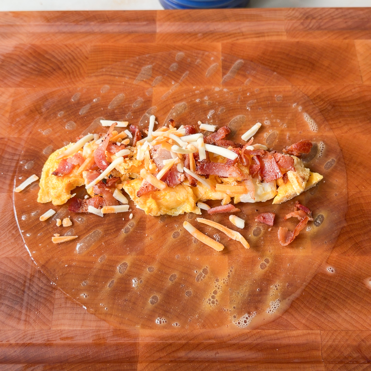 Lay on an oiled surface & add the eggs, bacon & cheese!