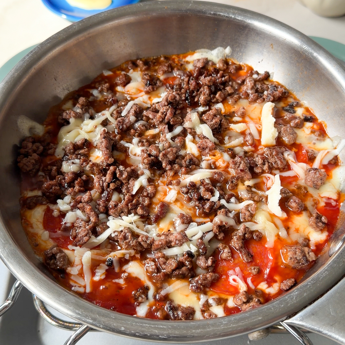 Add the tomato sauce, cheese, pepperoni & beef to a small skillet over low heat!