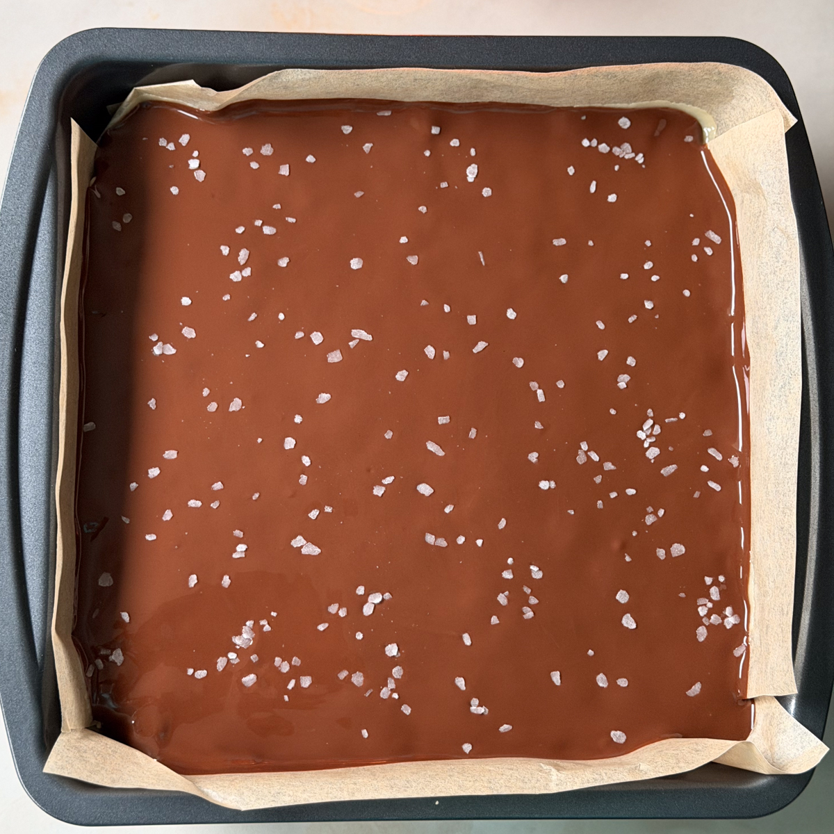 Pour the melted chocolate over the set caramel and spread evenly.