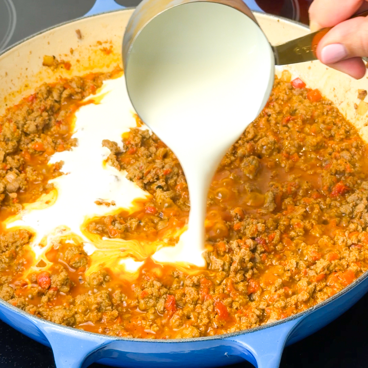 Add in the ajvar, pasta water & the heavy cream!